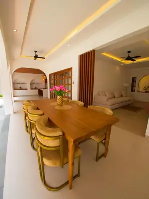 a dining room with a wooden table and chairs at Near Beach Villa in Seminyak