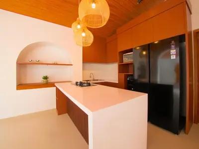 a kitchen with a black refrigerator and wooden cabinets at Near Beach Villa in Seminyak