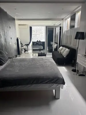 a bedroom with a bed and a living room at Minimalist apartment long term in Seminyak