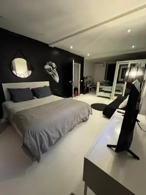 a bedroom with a bed and a desk with a computer at Minimalist apartment long term in Seminyak