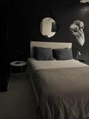 a bedroom with a bed with a mirror and a table at Minimalist apartment long term in Seminyak