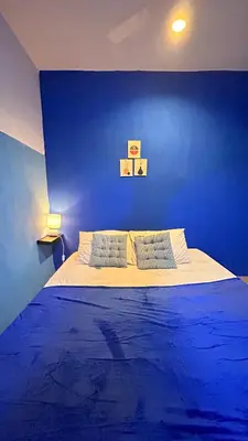a blue bedroom with a bed with a blue wall at A Room in Santorini House Room Near Airport Bali in Kuta
