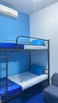 two bunk beds in a room with blue walls at A Room in Santorini House Room Near Airport Bali in Kuta