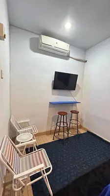 a room with a table and two chairs and a tv at A Room in Santorini House Room Near Airport Bali in Kuta