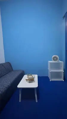 a blue room with a couch and a table at A Room in Santorini House Room Near Airport Bali in Kuta