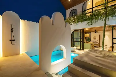 a home with a swimming pool and a cross on the wall at Villa Tibrava Umalas by BaliSuperHost in Canggu