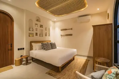 a bedroom with a white bed and a couch at Villa Tibrava Umalas by BaliSuperHost in Canggu