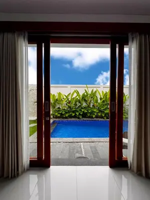an open glass door with a view of a swimming pool at Private Escape in Seminyak in Seminyak