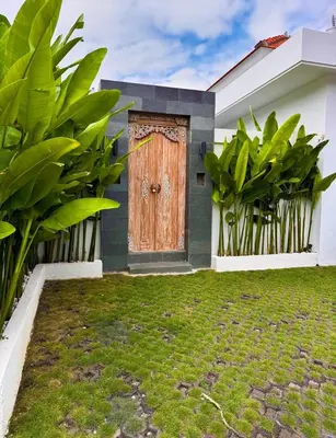 a house with a wooden door in a yard at Private Escape in Seminyak in Seminyak