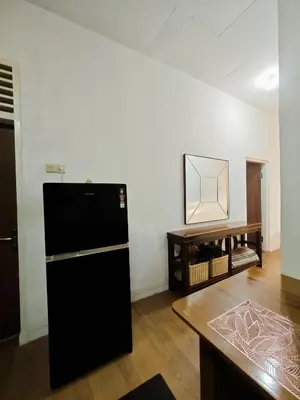 a black refrigerator in a room with a table at Holiday Home Bali in Denpasar