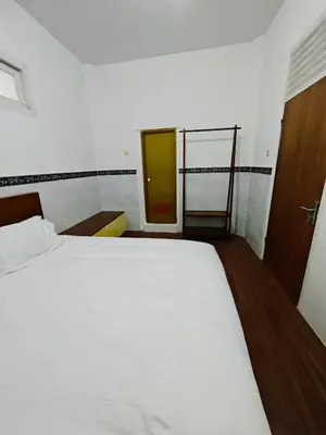 a bedroom with a large white bed and a ladder at Holiday Home Bali in Denpasar