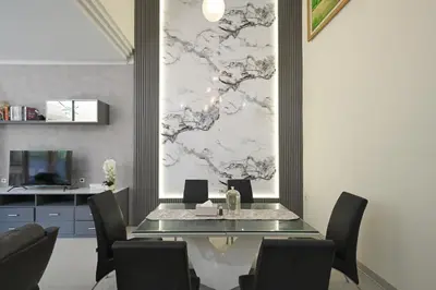 a dining room with a glass table and chairs at Puri Ratu Jimbaran with Private Pool in Jimbaran