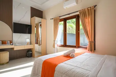 a bedroom with a large bed and a window at Puri Ratu Jimbaran with Private Pool in Jimbaran