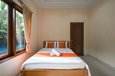 a bed in a room with a large window at Puri Ratu Jimbaran with Private Pool in Jimbaran