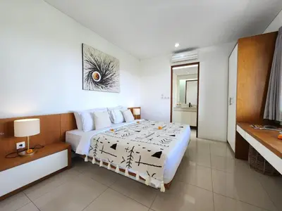 a bedroom with a bed and a desk in it at Villa Abigail Seminyak by Nagisa Bali in Seminyak