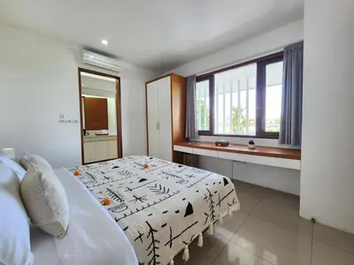 a bedroom with a bed and a window at Villa Abigail Seminyak by Nagisa Bali in Seminyak