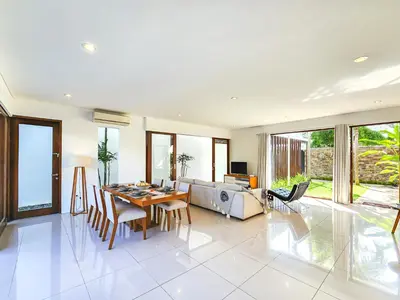 a living room with a table and a couch at Villa Abigail Seminyak by Nagisa Bali in Seminyak