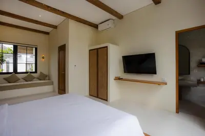 a bedroom with a white bed and a flat screen tv at Villa Batu Putih 2 Seminyak - No FLOOD in Seminyak
