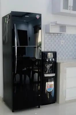 a black refrigerator in a kitchen with a table at Cherish Villa Umalas in Canggu