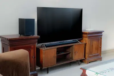 a flat screen tv on a wooden entertainment center at Cherish Villa Umalas in Canggu