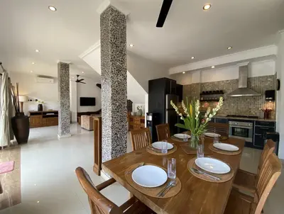 a kitchen and dining room with a wooden table and chairs at Amazing Villa in Seminyak Petitenget Top Location in Seminyak