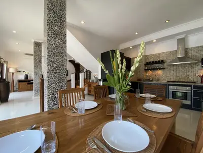 a kitchen and dining room with a wooden table at Amazing Villa in Seminyak Petitenget Top Location in Seminyak