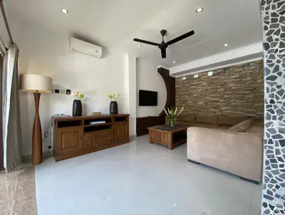 a living room with a couch and a brick wall at Amazing Villa in Seminyak Petitenget Top Location in Seminyak