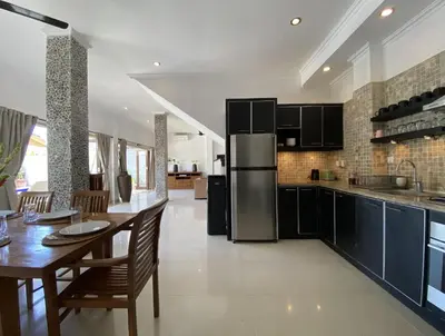 a kitchen with a dining table and a refrigerator at Amazing Villa in Seminyak Petitenget Top Location in Seminyak