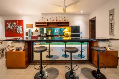 a kitchen with a large counter with stools at Villa Alopa Seminyak in Seminyak
