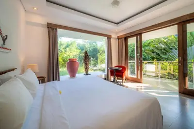 a bedroom with a large bed and a large window at Villa Alopa Seminyak in Seminyak