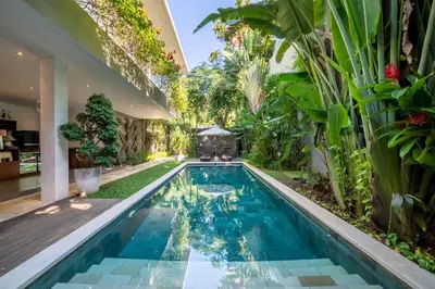 a swimming pool in the middle of a house with plants at Villa Alopa Seminyak in Seminyak