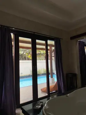a bathroom with a tub and a view of a pool at One BedRoom Villa with Private Pool near DPS Airport in Kuta