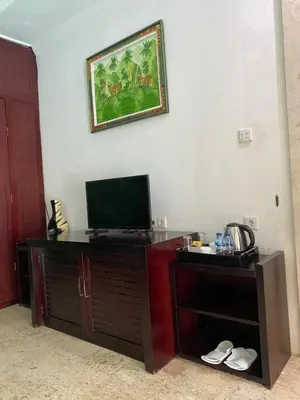 a room with a desk with a television on a wall at One BedRoom Villa with Private Pool near DPS Airport in Kuta