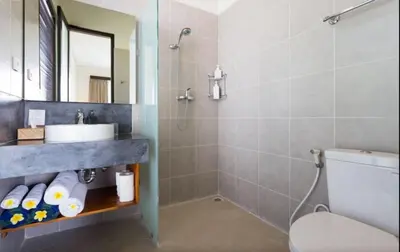 a bathroom with a sink and a toilet and a mirror at Villa Bteega sawah in Seminyak