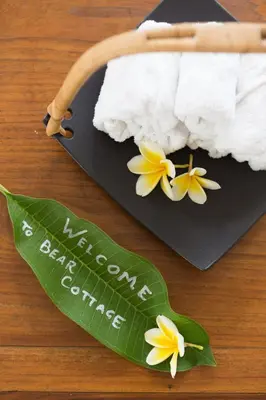 a black plate with white towels and yellow flowers on it at Bear Cottage 4 Bedroom Luxury Villa - Petitenget, Seminyak in Seminyak