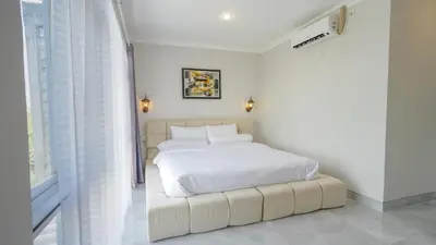 a white bedroom with a white bed and a window at Rumah Jimbaran Kuta 3 bedroom 9 pax SukaBali 1 in Jimbaran