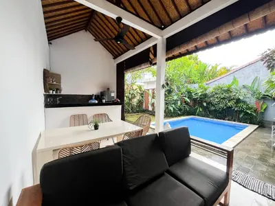 a living room with a couch and a swimming pool at Villa Kita Seminyak in Seminyak