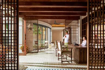 two people standing in a room with a table at Aahana Village Bali in Canggu