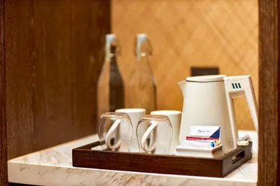 a tray with glasses and a coffee maker on a counter at Aahana Village Bali in Canggu
