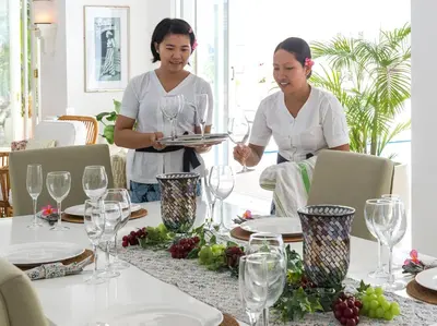 two women standing at a table with a tray of wine glasses at Villa Lulito in Seminyak