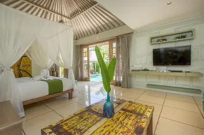 a bedroom with a bed and a vase with a plant at Villa Sky Li by Nagisa Bali in Seminyak