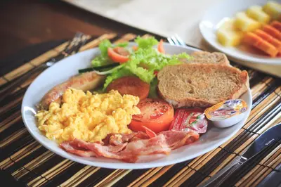 a plate of breakfast food with eggs bacon tomatoes and toast at Villa Sky Li by Nagisa Bali in Seminyak