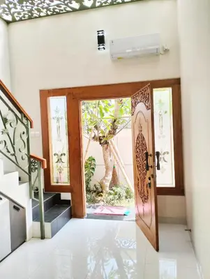 an open door in a house with a tree at Villa Sanur2 in Sanur