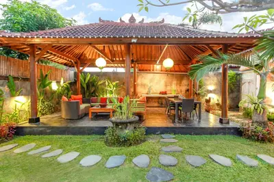 a wooden pavilion with a table and chairs in a yard at Villa Bali Caviar in Seminyak