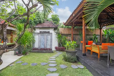 a garden with orange benches and a house at Villa Bali Caviar in Seminyak