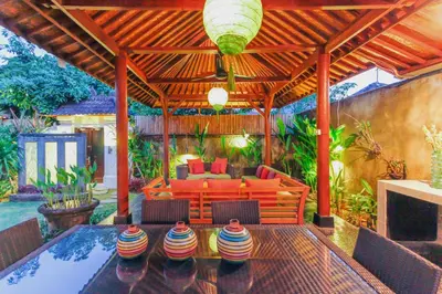an outdoor living room with a pool and a wooden pergola at Villa Bali Caviar in Seminyak
