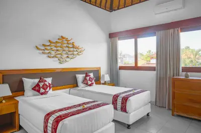 a hotel room with two beds and a window at Villa Bali Caviar in Seminyak