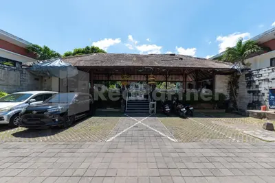a pavilion with a car parked in a parking lot at Ozz Hotel Kuta Bali manage by Ozz Group in Kuta