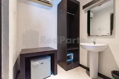 a bathroom with a sink and a mirror at Ozz Hotel Kuta Bali manage by Ozz Group in Kuta