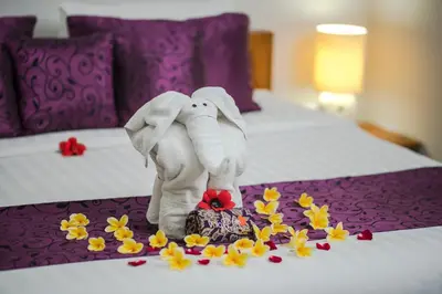 a stuffed elephant standing on a bed with flowers at Villa Rendezvous Bali in Seminyak
